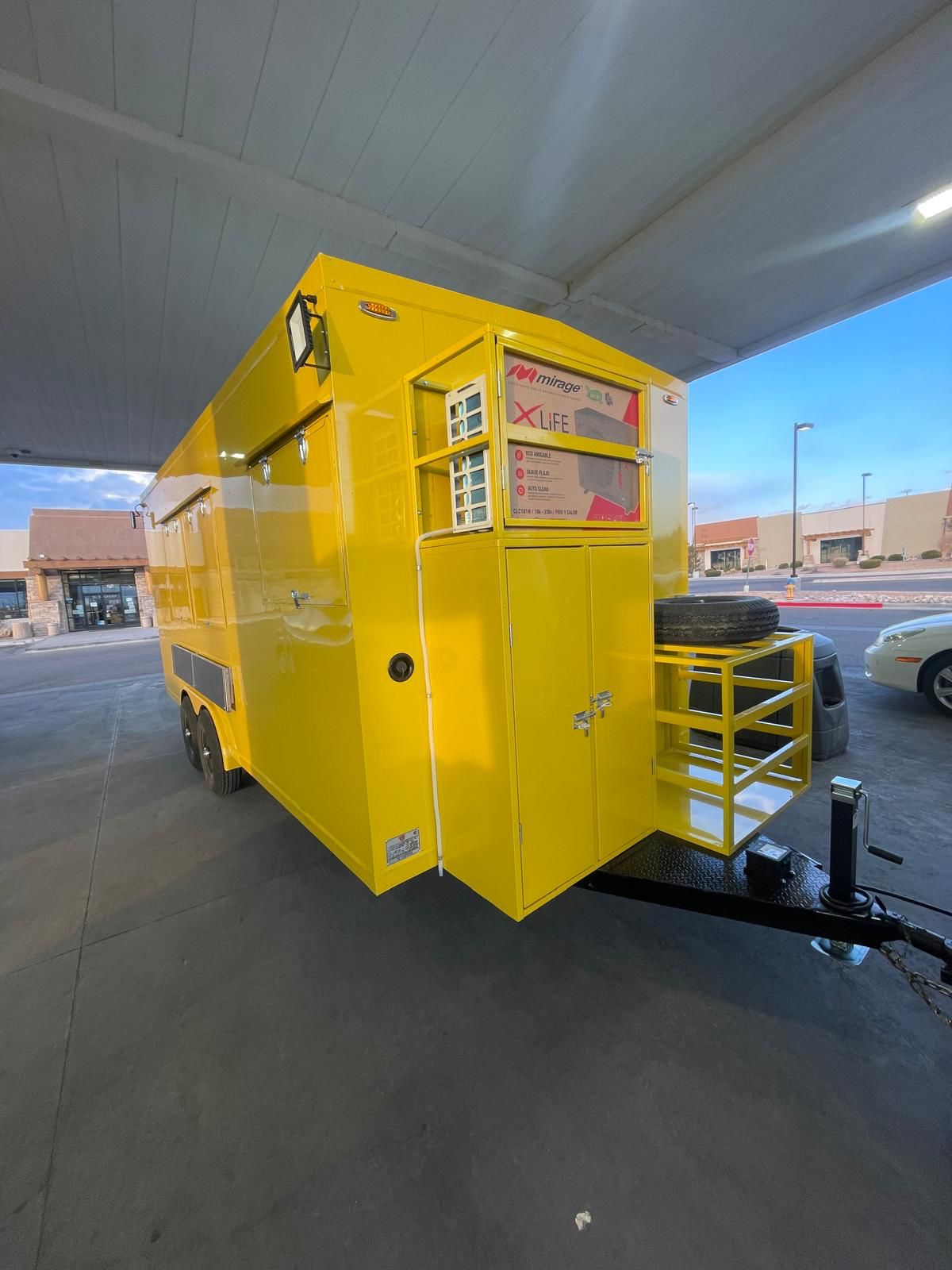 a yellow trailer with a tire on the back
